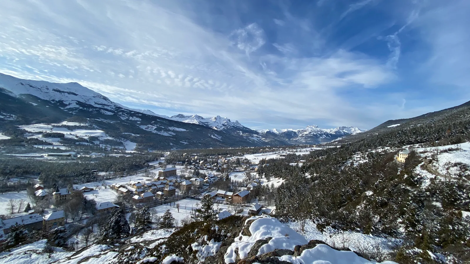 Vue sur un village enneigé et les montagnes de l’Ubaye